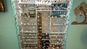 A closet with shelves and hanging storage, filled with neatly folded clothes and hanging items.