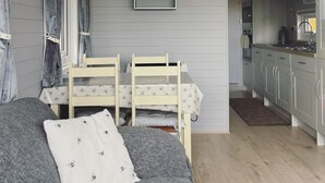 Ein gemütliches Zimmer mit einem Etagenbett, einer Couch und einer Küchenzeile.