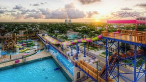 Un parc aquatique doté d’un grand toboggan aquatique, d’une piscine et d’une terrasse en bois.