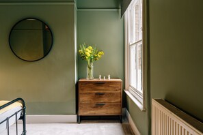 A room with a wooden dresser, a mirror, and a window. - Sanctuary-by-Sea  2 bed Apartment (Worthing)