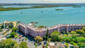 Hotel a più piani con parcheggio e vista su una vasta distesa d'acqua con barche.