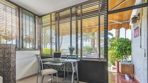 Ein moderner Arbeitsraum mit Schreibtisch, Stuhl und großen Fenstern mit Jalousien.