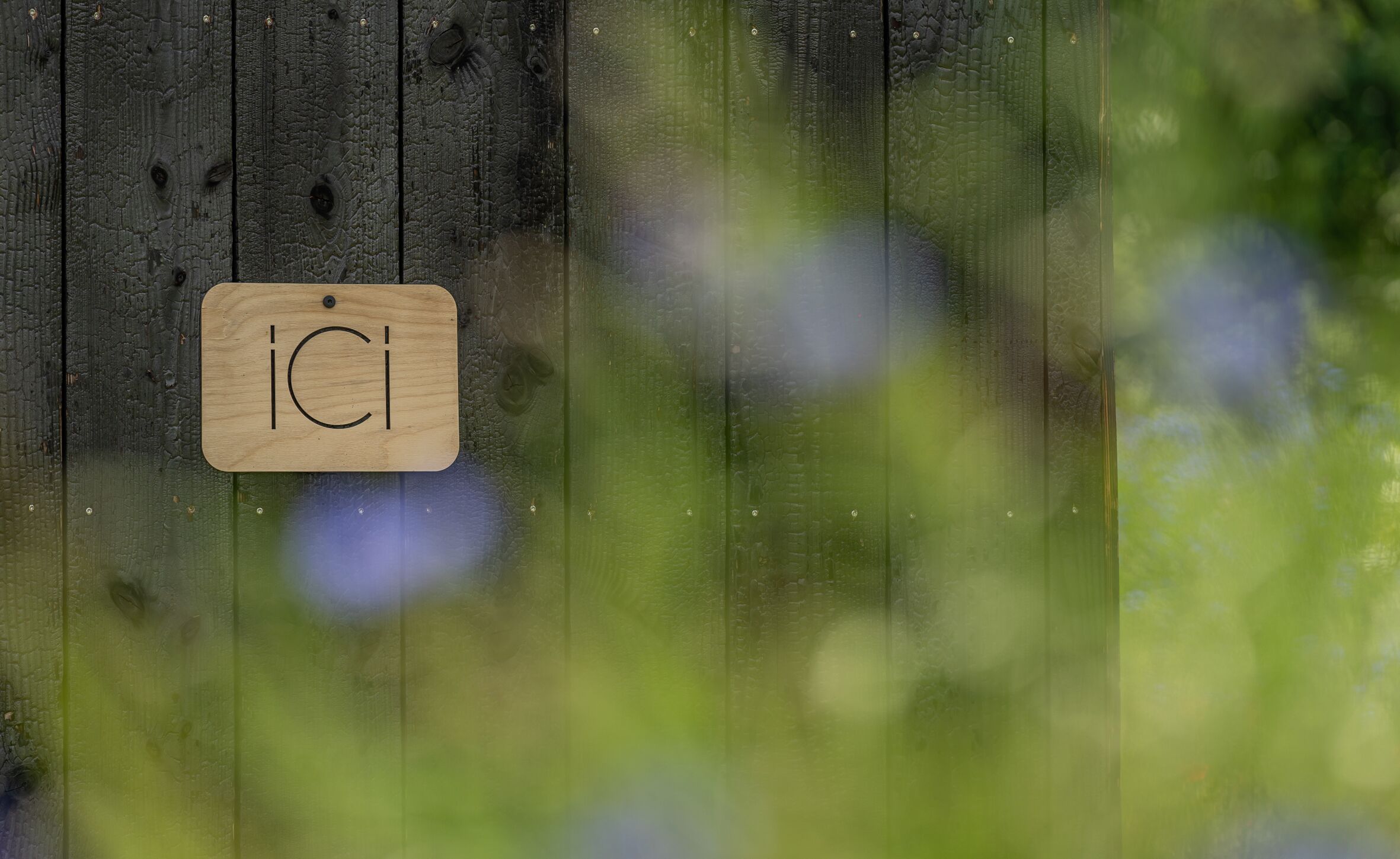 Un cartello di legno con le lettere "IC" su uno sfondo di legno rustico.