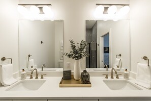 A modern bathroom with two sinks, a large mirror, and a potted plant. - Brand new 4 BR, 4Bath Townhome with amazing rooftop! (Nashville)