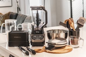 A kitchen counter with a toaster, blender, measuring cup, and various utensils. - Brand new 4 BR, 4Bath Townhome with amazing rooftop! (Nashville)