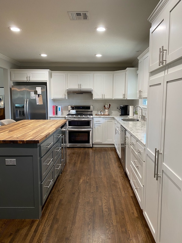Enjoy cooking in this well-equipped kitchen with a stainless steel refrigerator, double oven, and ample counter space.