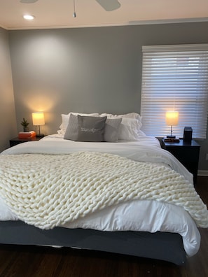 Relax in this serene bedroom with a large bed and soft lighting from bedside lamps.