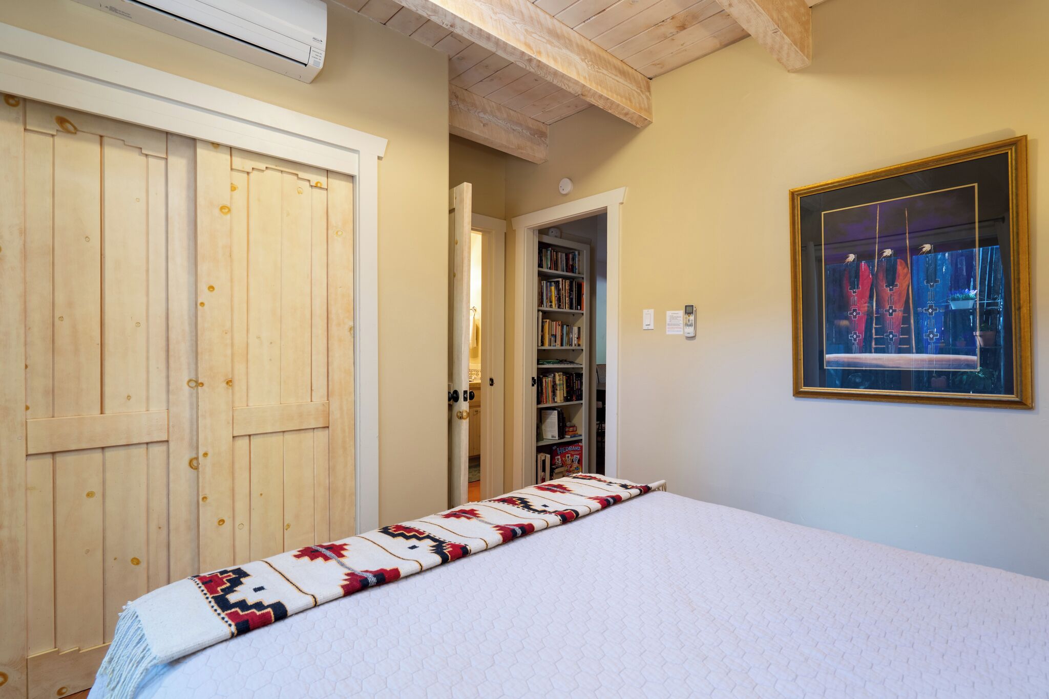 Una camera da letto con un letto, un'armadiatura in legno e una libreria.