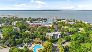 Eine Luftaufnahme eines Küstenresorts mit einer Marina, einem Schwimmbad und üppiger Vegetation.