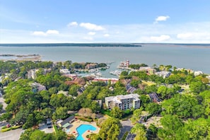 Eine Luftaufnahme eines Küstenresorts mit einer Marina, einem Schwimmbad und üppiger Vegetation.