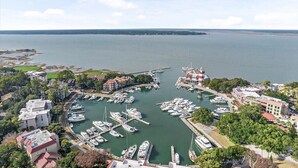 Un port de plaisance où sont amarrés de nombreux bateaux, entouré de bâtiments et de verdure.