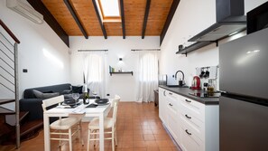 A compact kitchen with a dining area, a built-in oven, and a refrigerator.