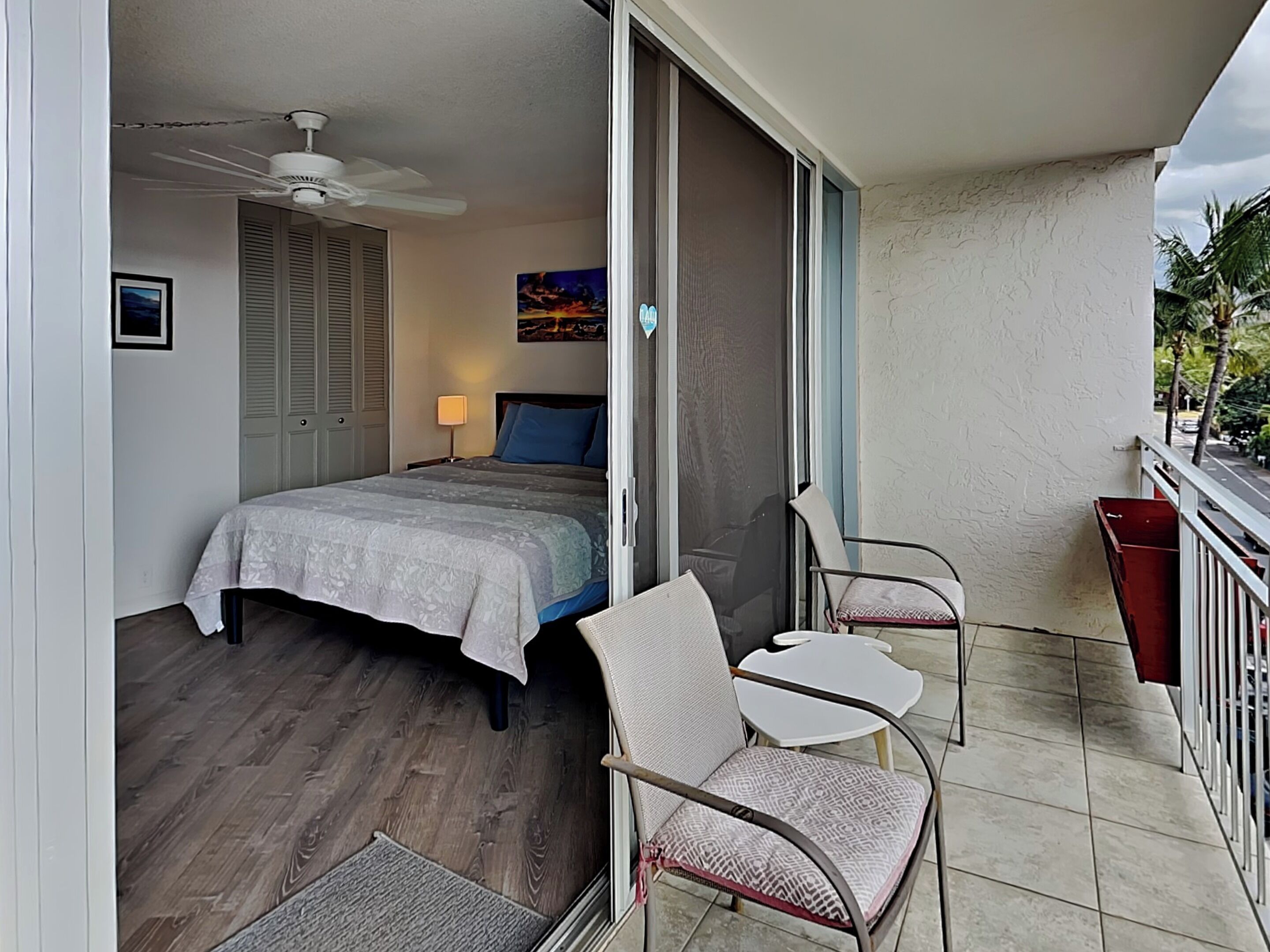A bedroom with a bed, a nightstand, a lamp, and a ceiling fan.