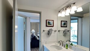 A modern bathroom with a large mirror, two sinks, and a towel rack.