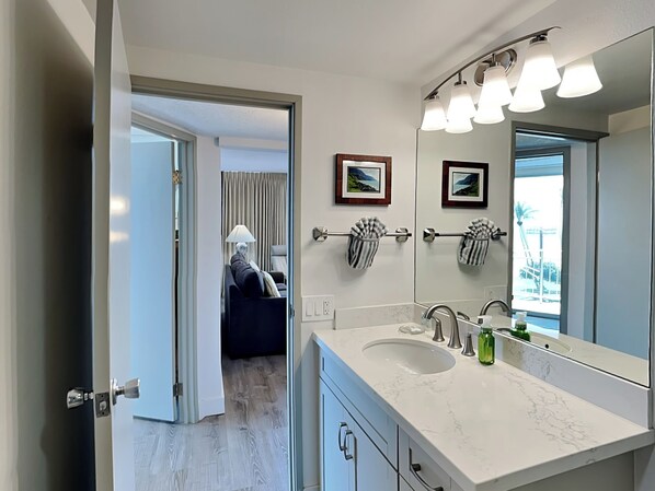 Un baño moderno con un espejo grande, dos lavamanos y un perchero para toallas.