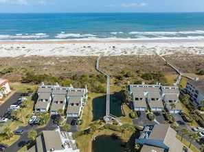 A coastal residential area with beachfront properties, a connecting bridge, and a parking lot. - Sea Winds 51 by Distinctive Beach Rentals (St. Augustine)