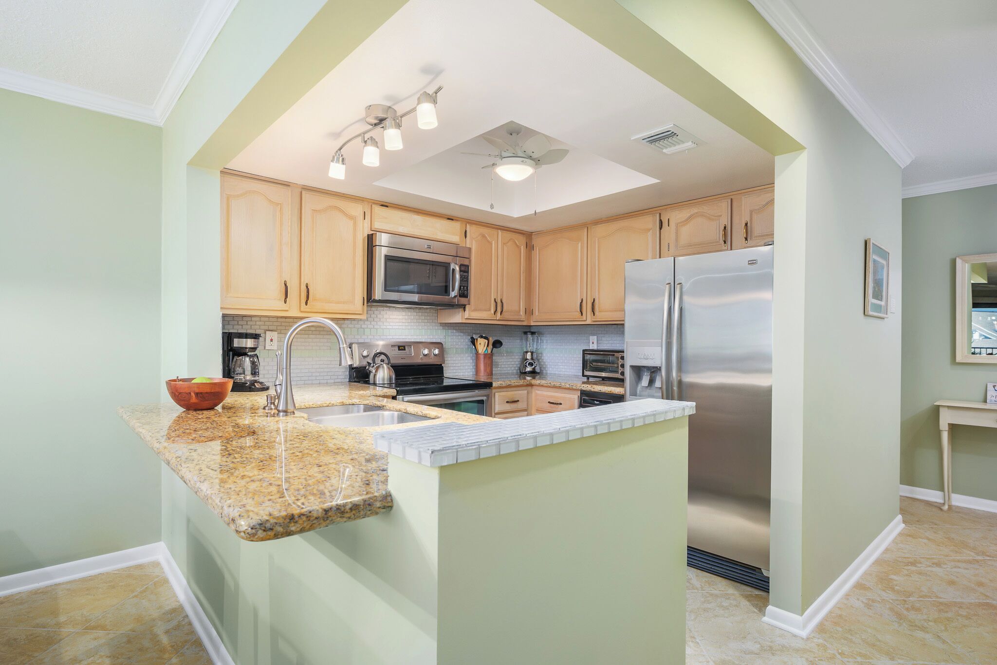 A kitchen with granite countertops, stainless steel appliances, and wooden cabinets.
