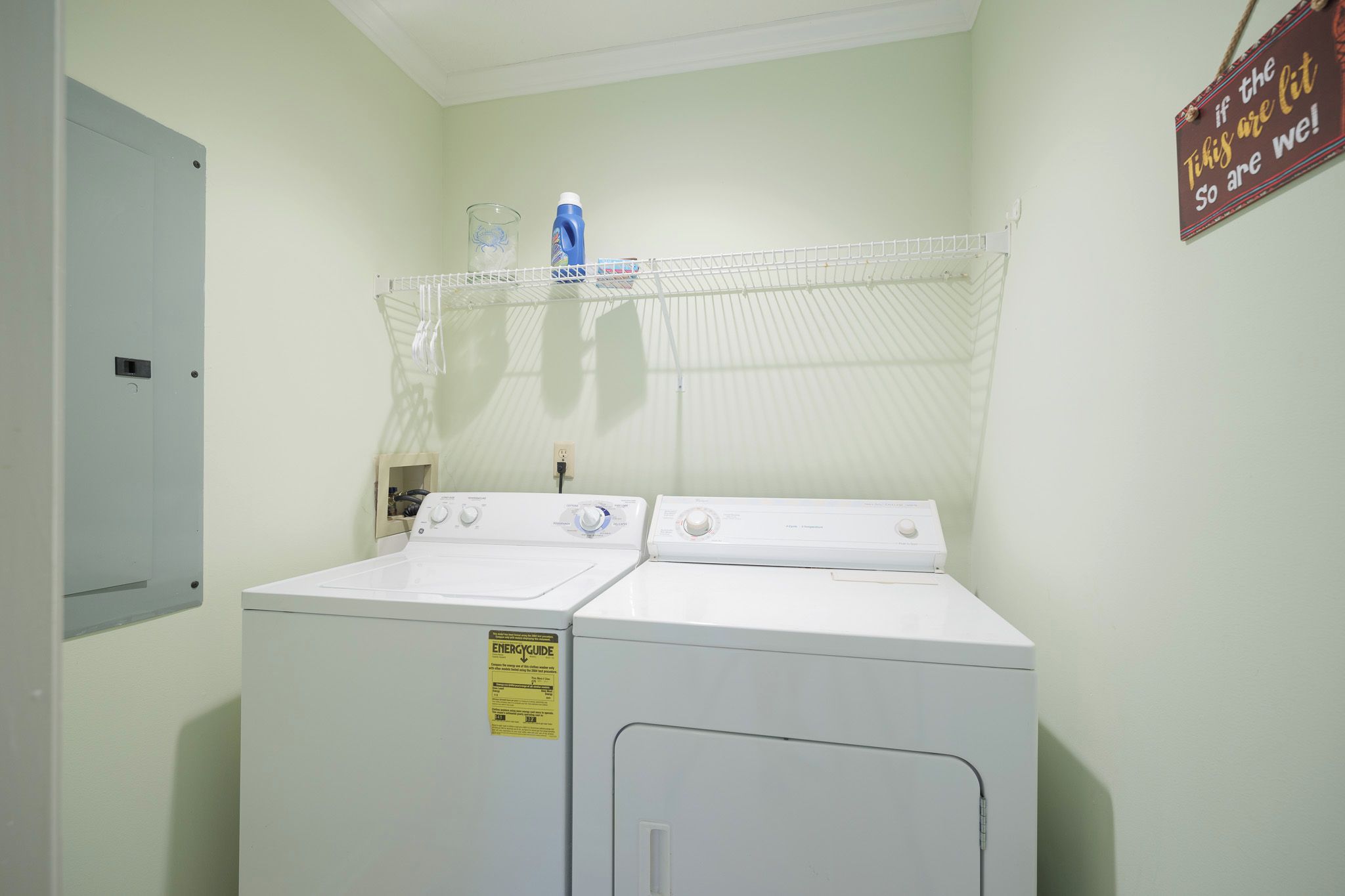 A laundry area with two white front-loading washers and a drying rack.