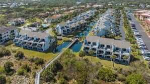 A resort with multiple buildings, a central pool, and a parking area. - Sea Winds 51 by Distinctive Beach Rentals (St. Augustine)