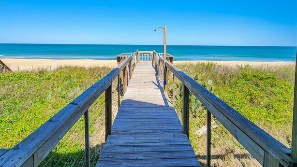 A wooden boardwalk leading to a beach with clear skies. - 🏖️ Someplace Else - Oceanfront 4 BR Townhome w/Gorgeous Sunrise Views 🌅 (Southern Shores)