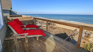 A wooden deck with two red lounge chairs facing the ocean. - 🏖️ Someplace Else - Oceanfront 4 BR Townhome w/Gorgeous Sunrise Views 🌅 (Southern Shores)