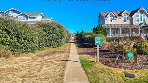 A pathway leading to a residential area with houses on both sides. - Capt'n Rons - 🏖️ 4BR Southern Shores Oceanside home w/Private Pool 🏖️ (Southern Shores)