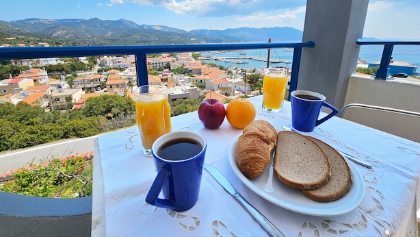 A table with breakfast items and a scenic view. - Pavlis Studios Ormos (Samos)