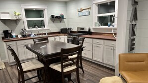 A modern kitchen with white cabinets, a wooden dining table, and a built-in oven. - Lake Daze, Blue Cottage <1mile to Jamestown Marina with space to trailer boat. (Jamestown)