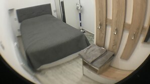 A bedroom with a bed, a wardrobe, a mirror, and a door. - Charming apartment in the old center of Madrid (Madrid)