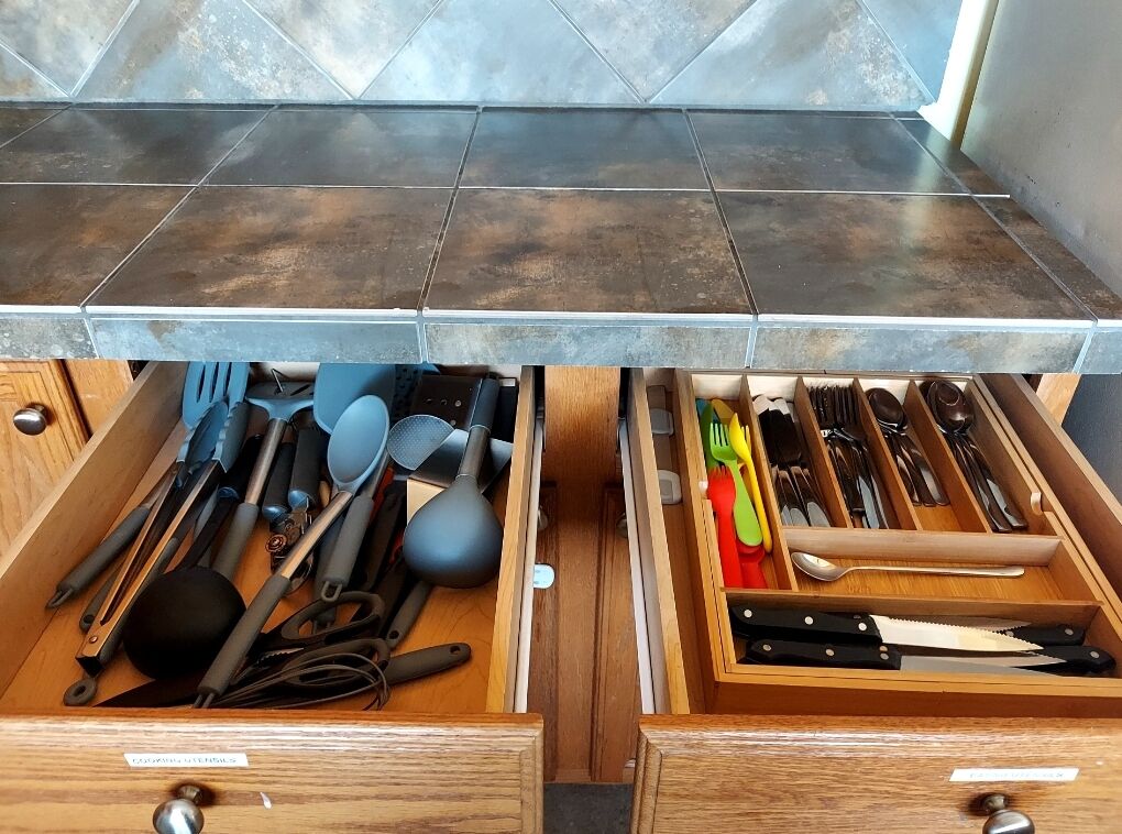 A kitchen drawer with utensils and kitchen tools.