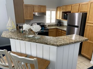 Enjoy cooking in this well-equipped kitchen with a granite countertop, stainless steel appliances, and an oven.