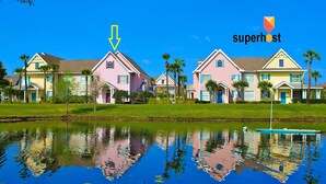 Una hilera de casas de colores pastel reflejadas en aguas tranquilas.