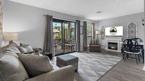 A living room with a sofa, ottoman, and a fireplace. - Private Balcony, Fireplace & King Bed | Near Golf & Entertainment in Branson (Branson)