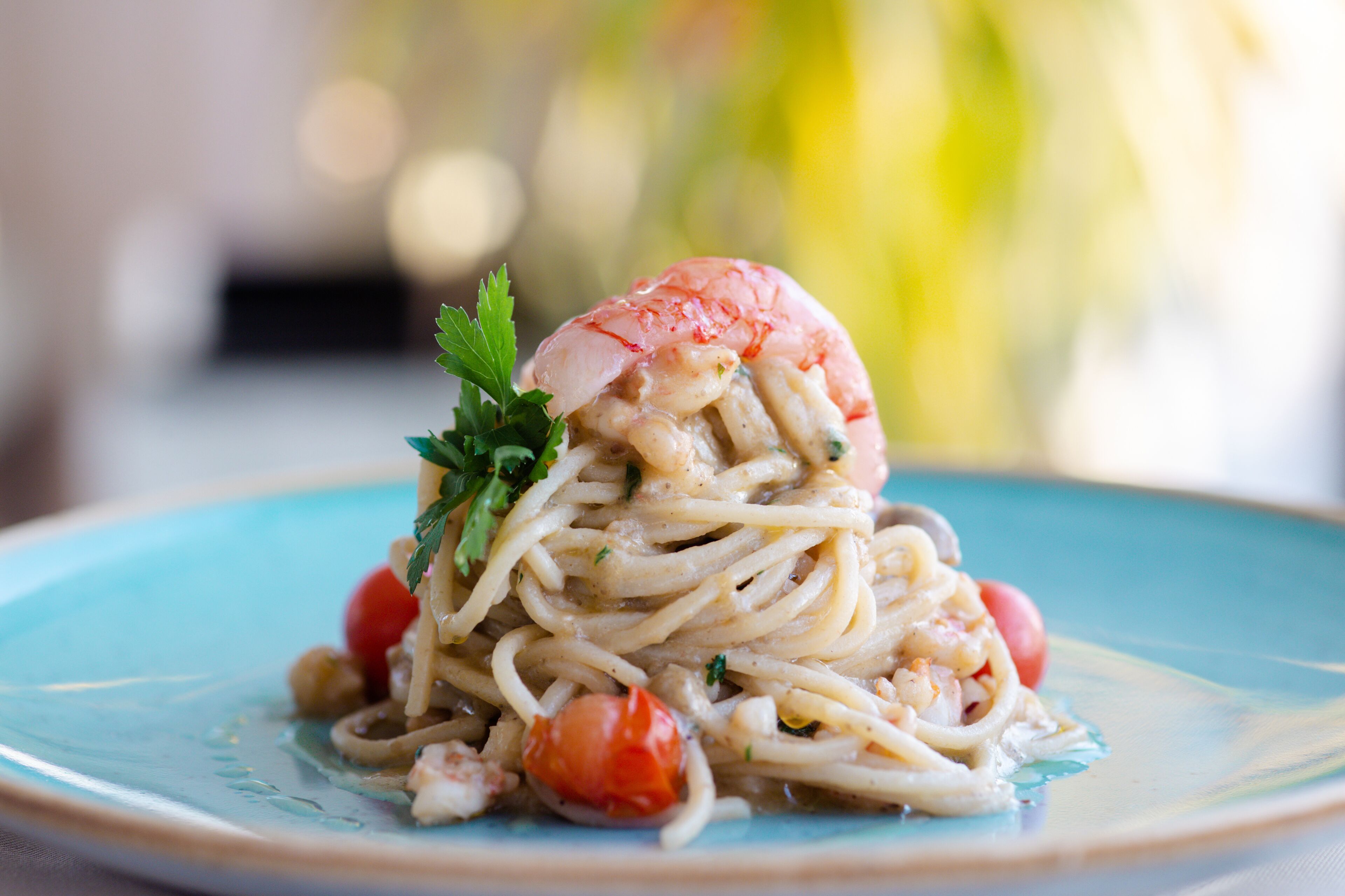 A plate of spaghetti with shrimp and cherry tomatoes.