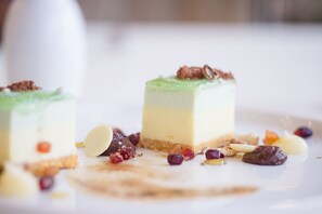 A dessert with a layered structure, garnished with nuts and dried fruits. - Marbella Beach Hotel (Golem)