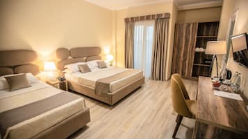 Deluxe Triple Room | Minibar, in-room safe, individually decorated, desk