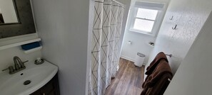 Tina con regadera, toallas, jabón, papel de baño 