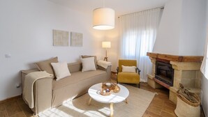 Ein gemütliches Wohnzimmer mit Sofa, Sessel und Kamin.