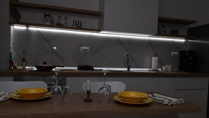 Eine moderne Küche mit einer zentralen Kochinsel, einem eingebauten Backofen und einem Weinschrank über der Arbeitsfläche.