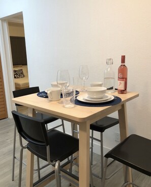 A dining table set with white plates, bowls, and glasses, a bottle of water, and a bottle of rosé wine. - Miami’s Wynwood Art District 10mins from the beach & MiamiHeat Arena (Miami)