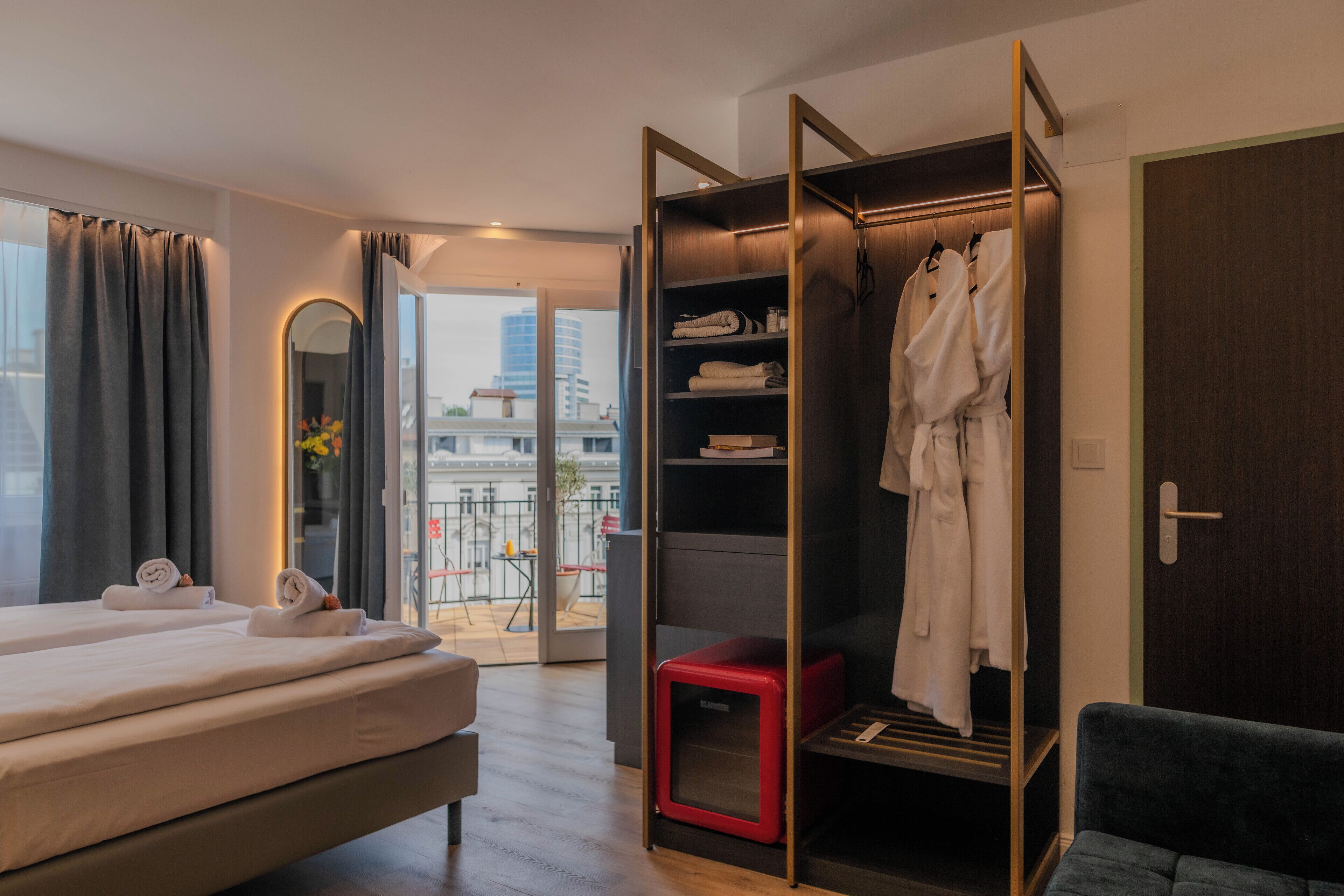 Una habitación de hotel con cama, vestidor y vistas a la ciudad.