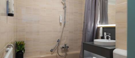 Ein modernes Badezimmer mit Badewanne, Dusche, Waschbecken und Toilette.