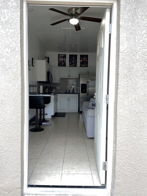 Enjoy cooking in this well-equipped kitchen with a stainless steel refrigerator, white cabinetry, and a tiled backsplash.