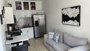 Enjoy a comfortable stay in this compact living space with a modern kitchen, sofa, and sink.