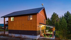 A wooden cabin with a porch and outdoor seating area.