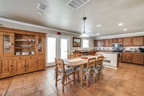 Enjoy cooking in this well-equipped kitchen with a central island, appliances, and a dining area.