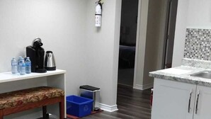 Une cuisine moderne équipée d’un plan de travail, d’une machine à café et d’un extincteur.