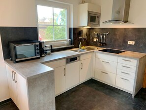 Een koelkast, een microgolfoven, een kookplaat, een vaatwasser