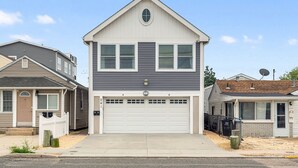 Une maison à deux étages avec un garage, un porche à l’avant et une antenne parabolique.