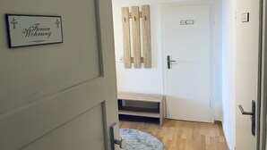 Un couloir avec une porte portant l’inscription « Appartement de vacances » et une autre porte avec une pancarte indiquant « Hôtel ».